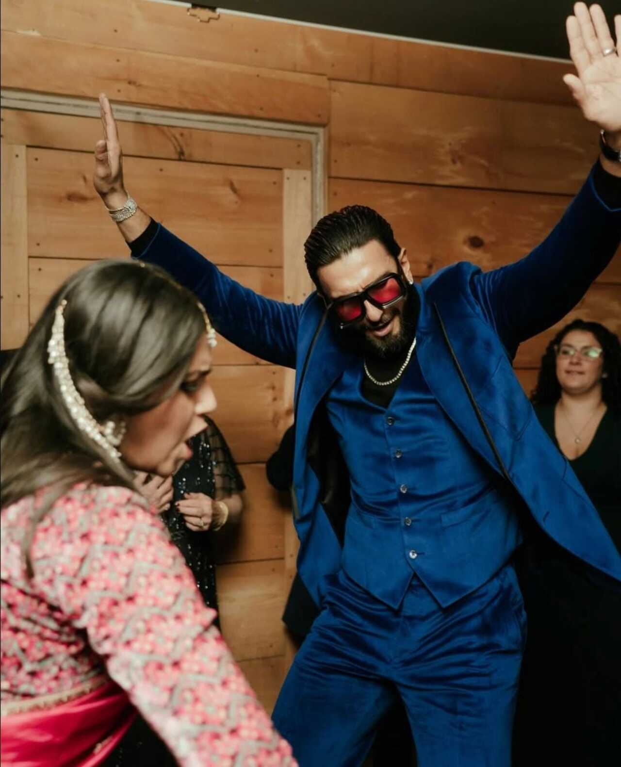 The Dhurandhar star was seen wearing a plush midnight-blue velvet suit, styled with a matching vest, statement red-tinted sunglasses, layered chains and a neatly groomed beard.